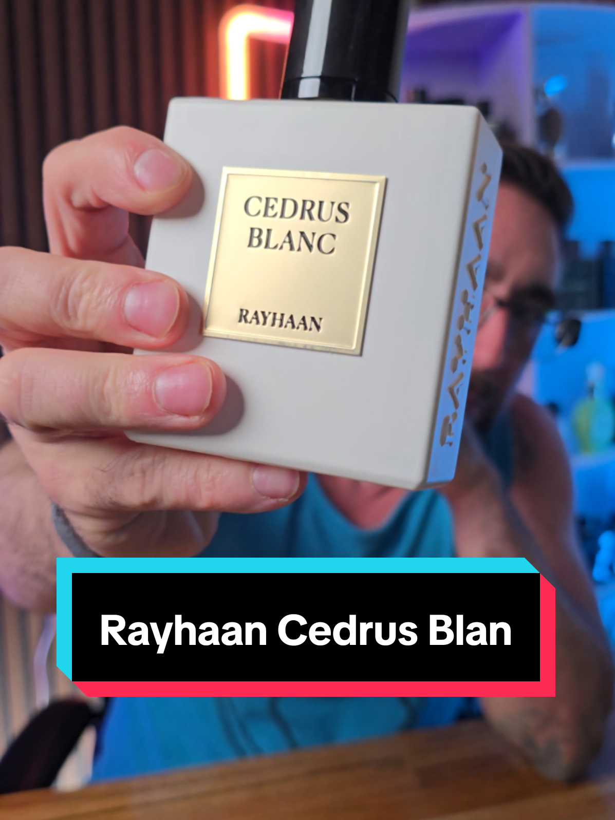 Loren Noble presenting a white Rayhaan Cedrus Blanc fragrance bottle