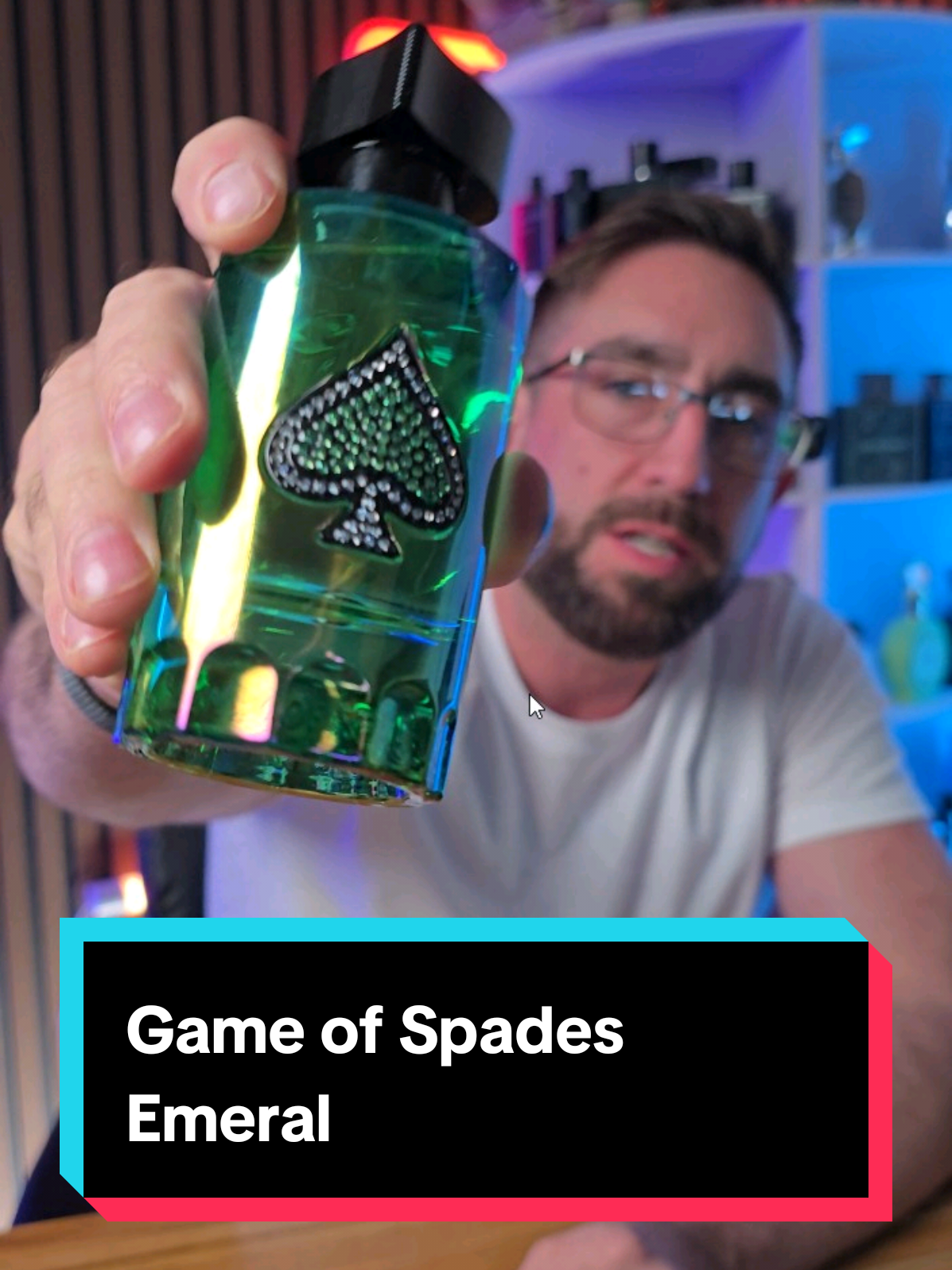 Loren Noble presenting a green Game of Spades Emerald fragrance bottle