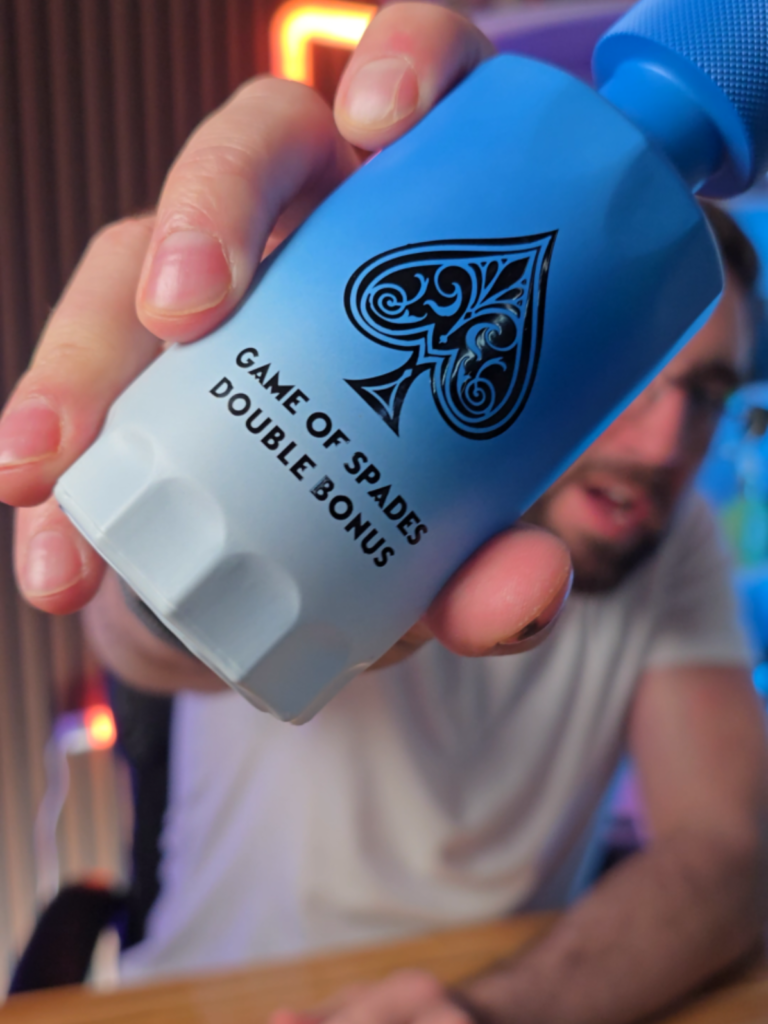 Loren Noble holding a Game of Spades Double Bonus fragrance bottle close to the camera
